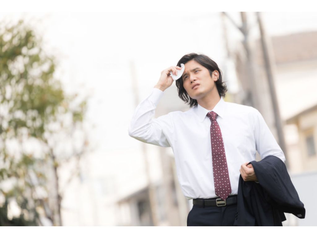 湿気と暑さで汗だくの男性